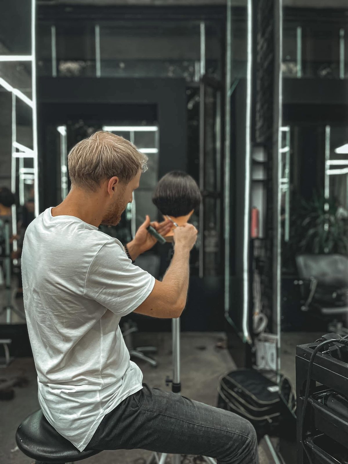 Alexandru tunde în salon, între oglinzi și benzi de lumină